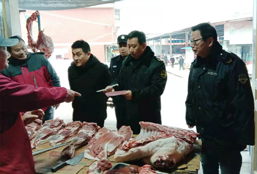 圖為執(zhí)法人員開展豬肉市場檢查.jpg