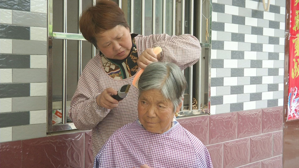 圖為黃志梅為她婆婆理發(fā).jpg