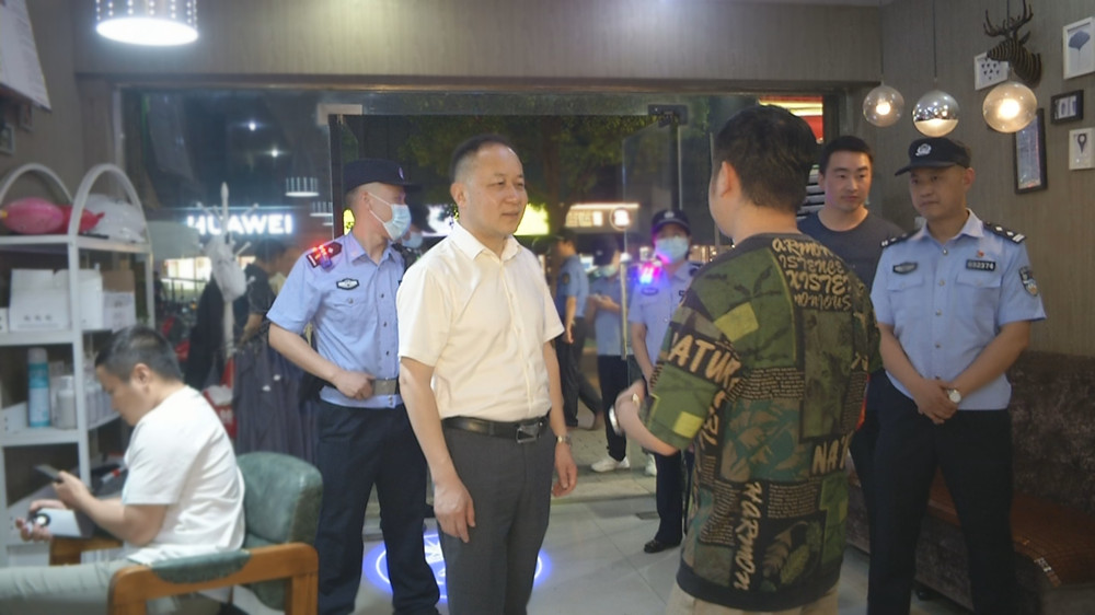 圖為王中龍在方圓薈附近與一理發(fā)店店家交流時的情景.jpg
