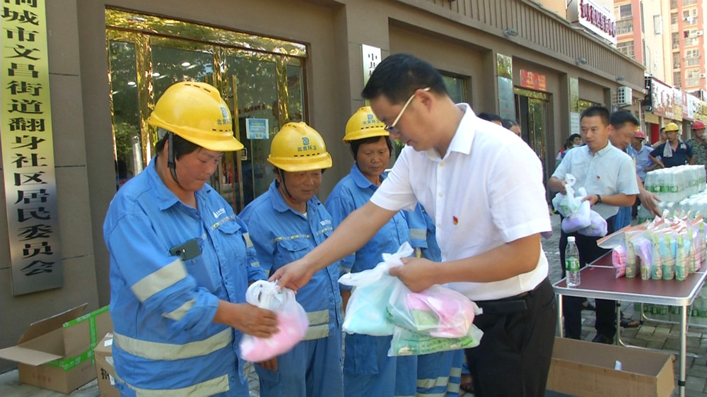 圖為活動(dòng)單位向環(huán)衛(wèi)工人發(fā)放清涼小禮包市的情景.jpg