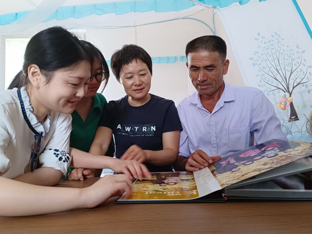 圖為王古明一家看相冊.jpg