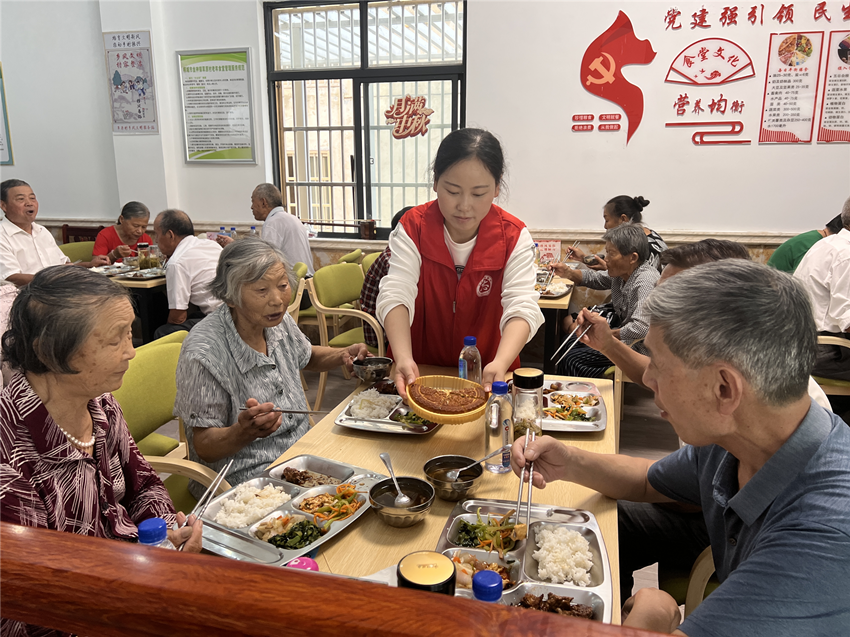 圖為志愿者為老人分發(fā)月餅。.png