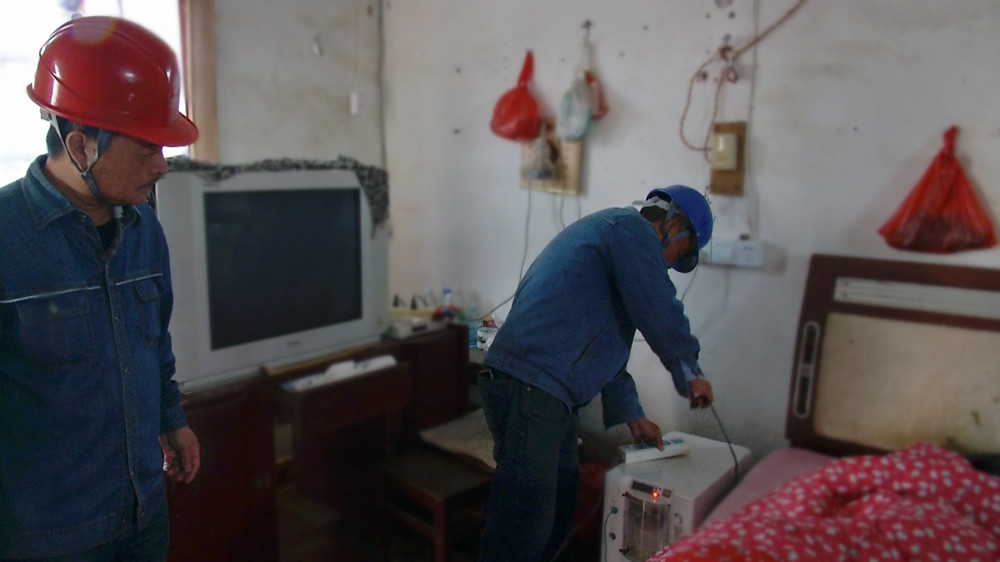 圖為呂亭中心供電所工作人員正在給江老老伴的呼吸機(jī)接通臨時(shí)電源.jpg