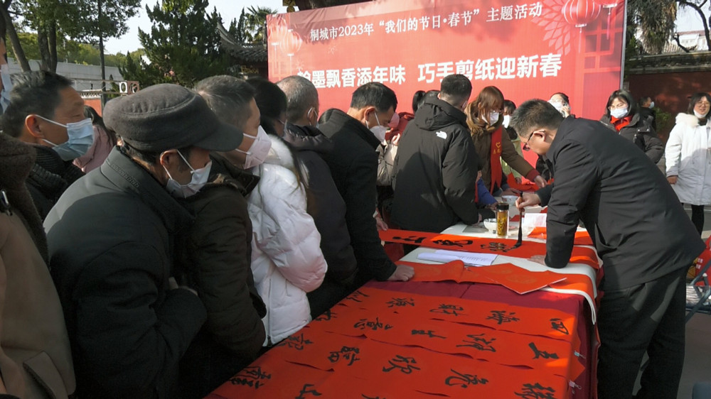 圖為市書法協(xié)會的書法家們正在揮毫潑墨為市民免費書寫春聯(lián) .jpg
