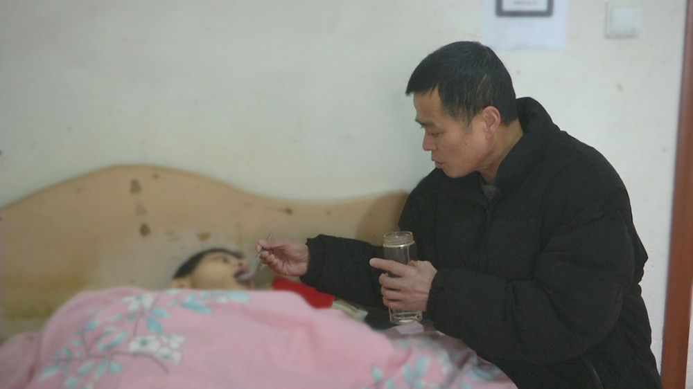 圖為李三春在喂兒子喝水時的情景.jpg