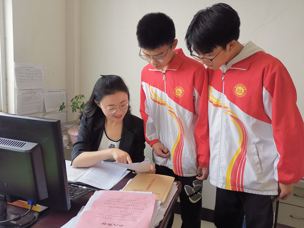 圖為龔虹輔導學生作業(yè)。.jpg