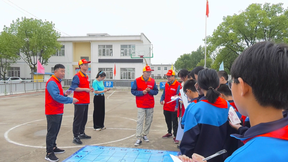 圖為國網(wǎng)桐城市供電公司黨員志愿者正在和學(xué)生一起玩益智游戲.jpg