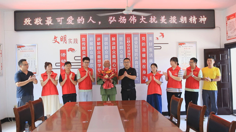 圖為青年大學(xué)生為倪晉全老戰(zhàn)士送上鮮花并致以崇高的敬意.jpg