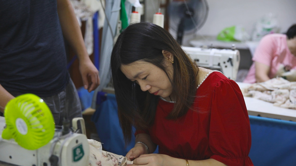 圖為正在家樓下服裝廠里工作的郭金妹.jpg