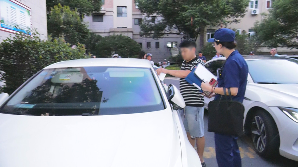 圖為檢查人員正在對一占用消防通道車主進行教育警告.jpg