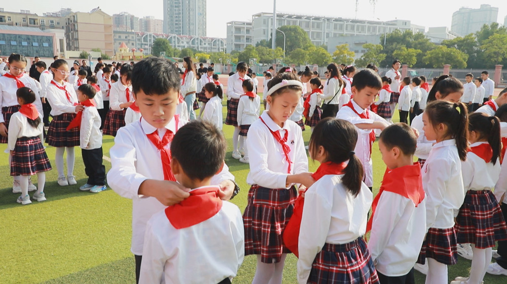圖為老隊(duì)員為新隊(duì)員佩戴紅領(lǐng)巾.jpg