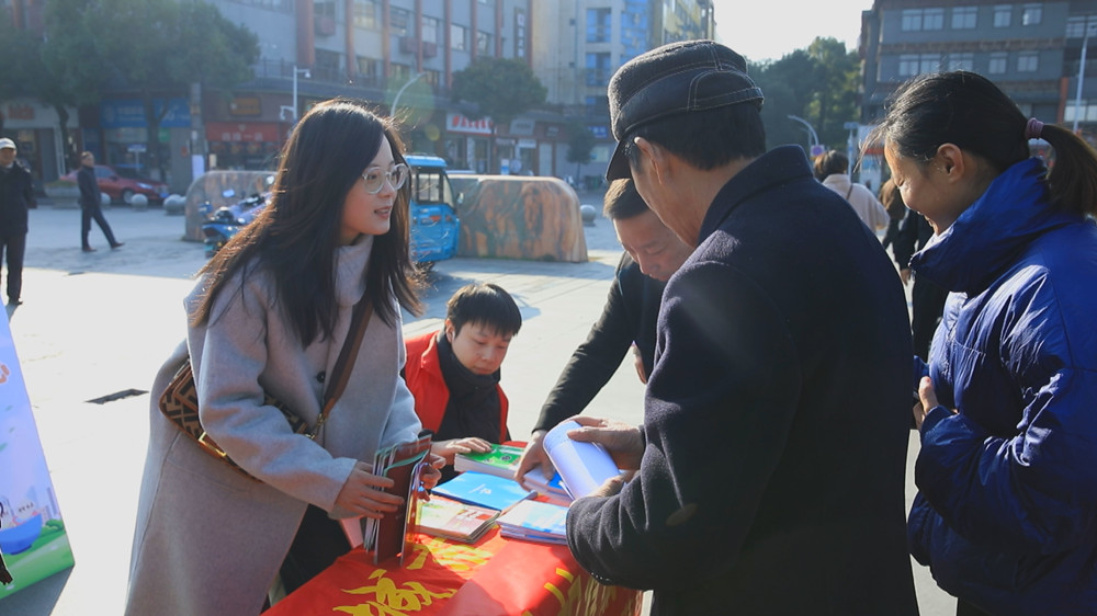 圖為工作人員正在為過往群眾發(fā)放宣傳材料，并答疑解惑。.jpg