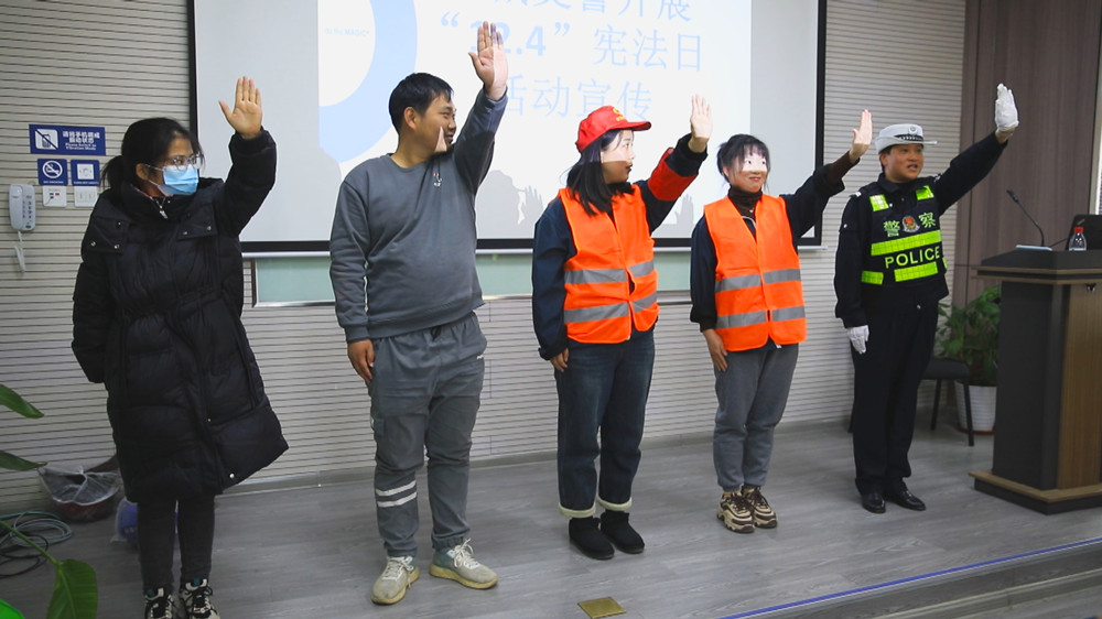 圖為宣傳民警正在教企業(yè)員工交警手勢操.jpg