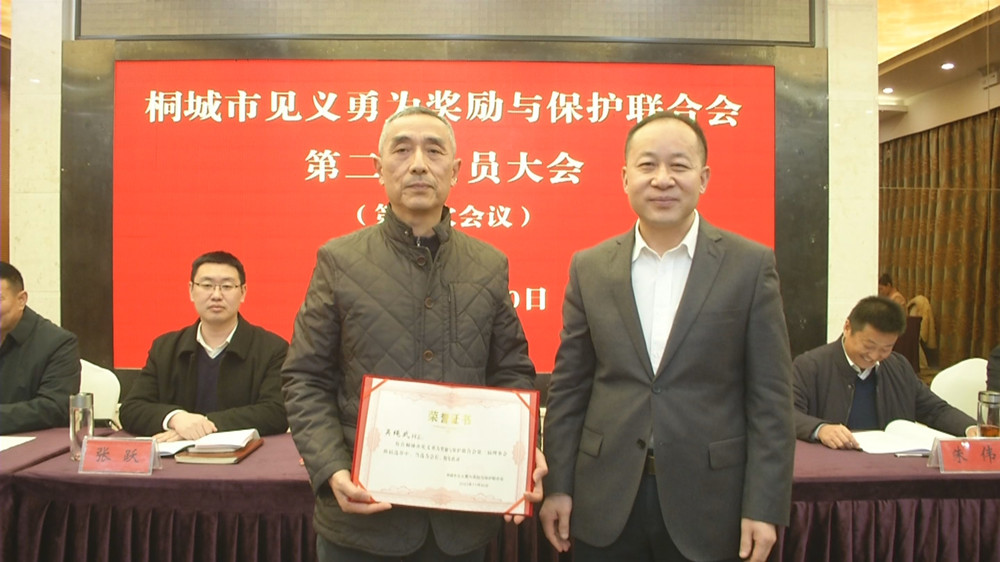 圖為市委常委、政法委書記為新當(dāng)選的桐城市第二屆見義勇為余保護(hù)聯(lián)合會會長吳繩武頒發(fā)任命證書.jpg