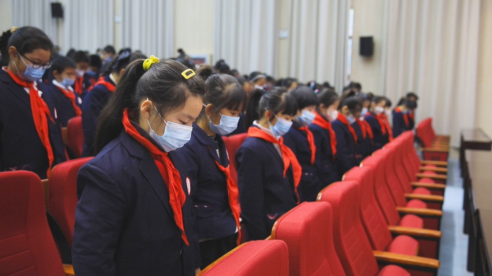 圖為學(xué)生們正在老師的帶領(lǐng)下為南京大屠殺不幸罹難同胞默哀.jpg