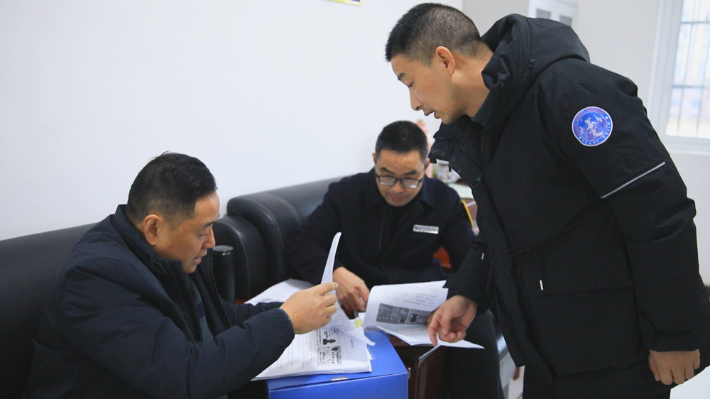 圖為農民工維權工作組正在某項目工地查閱農民工工資發(fā)放臺賬.jpg