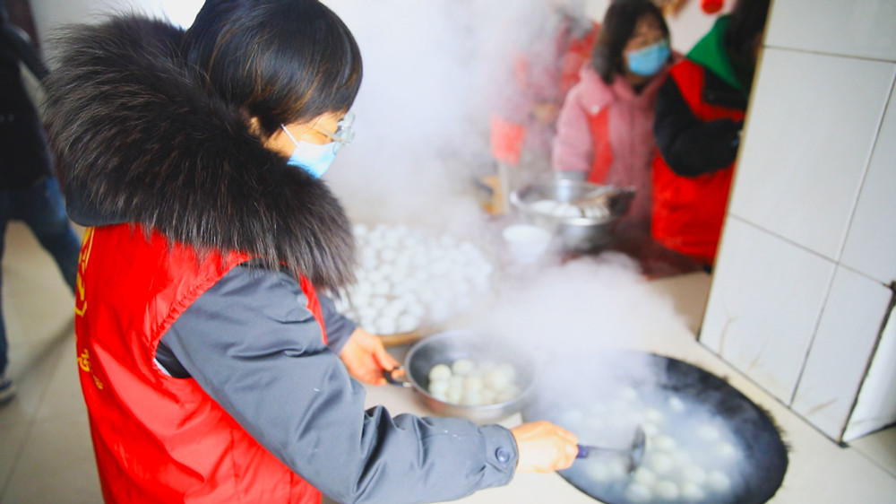 圖為范崗鎮(zhèn)志愿者正在幫忙煮湯圓.jpg