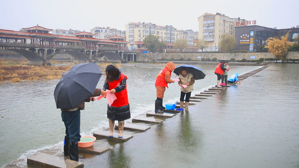 圖為志愿者正在勸導(dǎo)居民不要下河洗衣.jpg