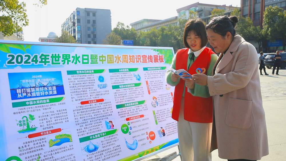 圖為現(xiàn)場工作人員正在給過往市民普及節(jié)約用水知識(shí).jpg