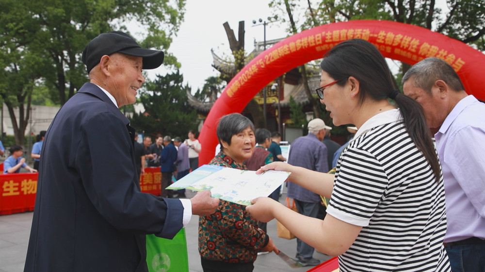 圖為現(xiàn)場工作人員正在向過往市民發(fā)放宣傳材料，講解生物多樣性知識。.jpg