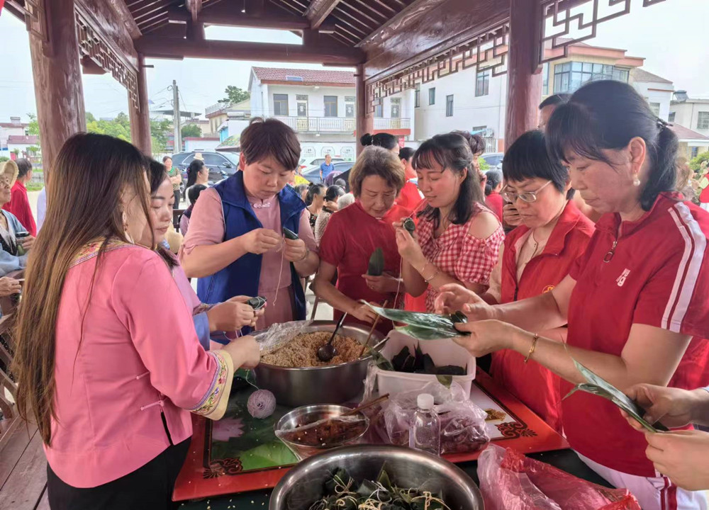 圖為村民和志愿者們共同包粽子。.jpg
