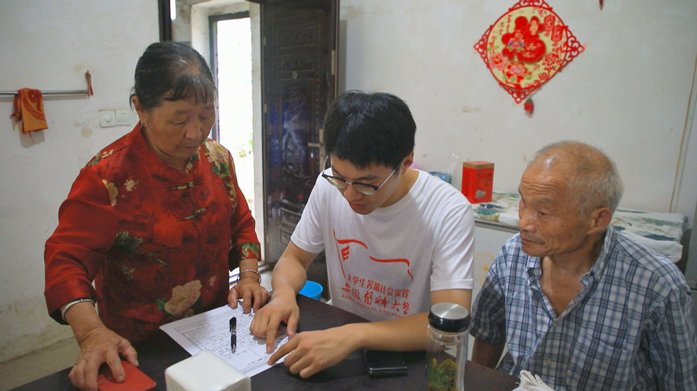圖為安徽醫(yī)科大學(xué)暑期“三下鄉(xiāng)”社會實(shí)踐團(tuán)隊(duì)正在村民家長開展問卷調(diào)查1.jpg