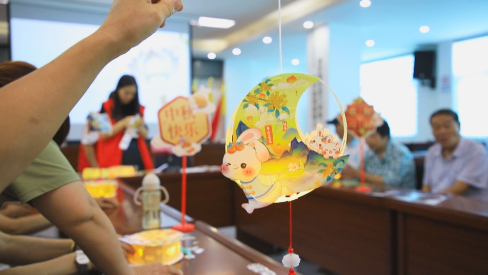 圖為居民正在展示制作完成的花燈1.jpg