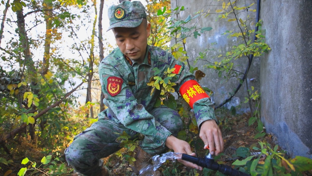 圖為龍眠街道龍眠村護林員正在檢查蓄水池蓄放水功能.jpg