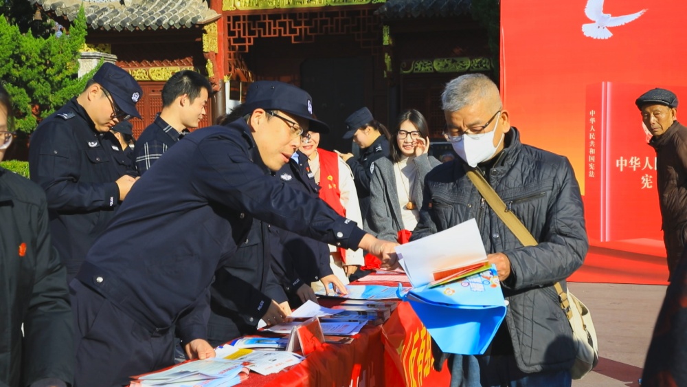 圖為工作人員正在為過往市民講解相關(guān)法律條文.jpg