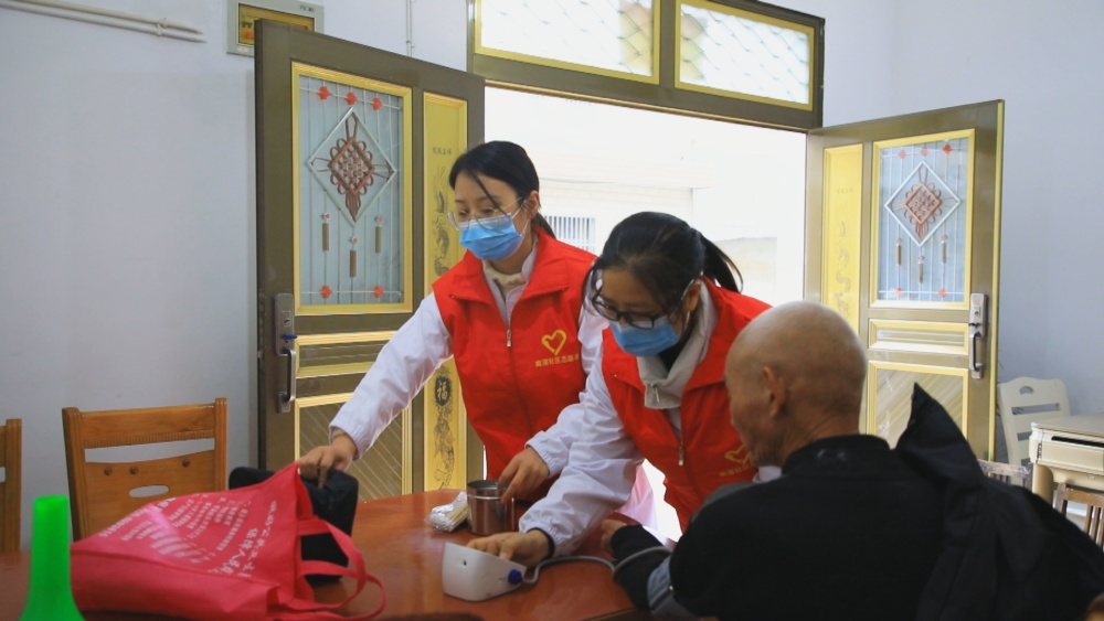 圖為龍眠街道南演社區(qū)志愿者正在為社區(qū)老人開展義診服務(wù).jpg