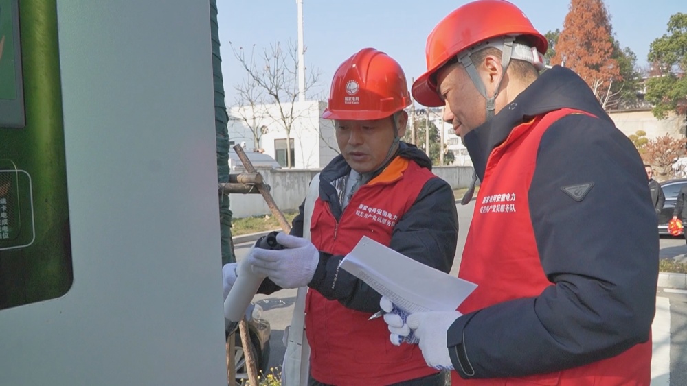 圖為工作人員在檢查充電設(shè)備.jpg