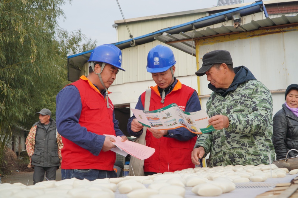 圖中工作人員向居民科普用電安全知識.JPG