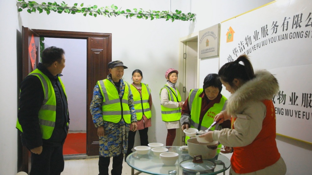 圖為社區(qū)工作人員將熱氣騰騰獻(xiàn)給社區(qū)環(huán)衛(wèi)和保安等工作人員.jpg