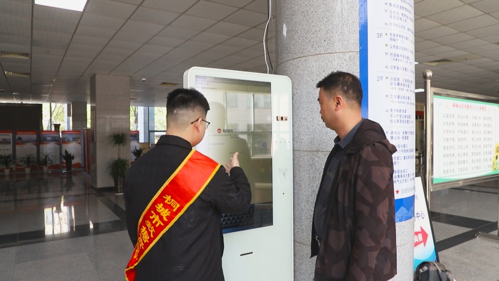 圖為市民汪先生正在工作人員的引導(dǎo)下使用政務(wù)服務(wù)智能導(dǎo)辦助手辦理業(yè)務(wù).jpg