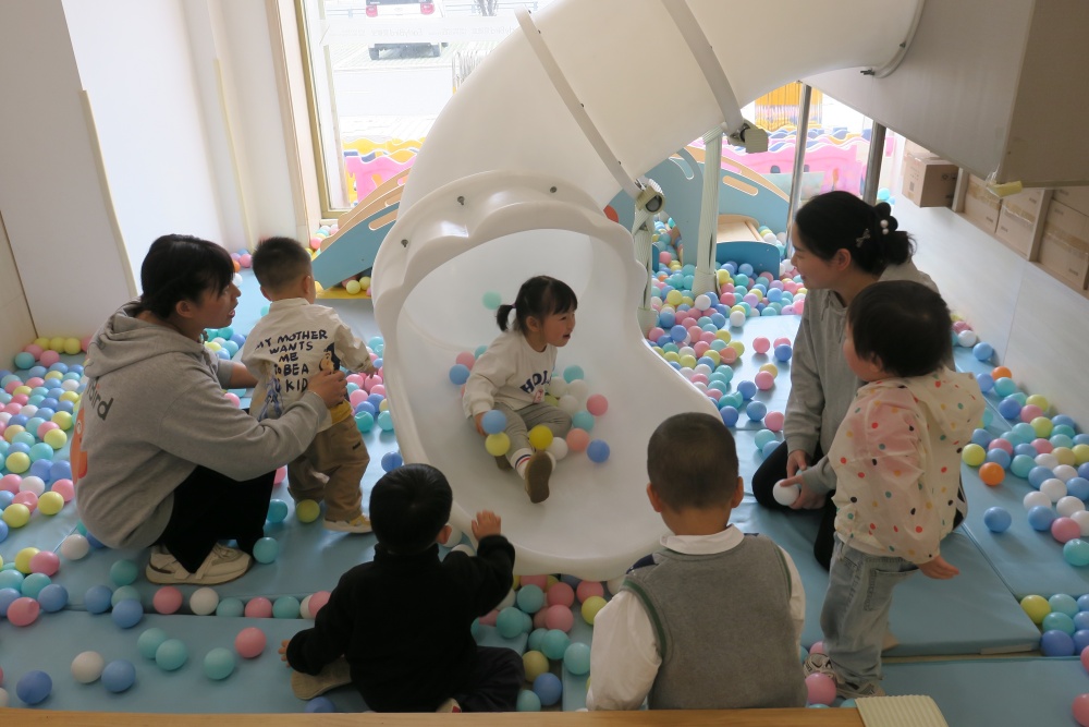 托育中心內幼師和保育員帶著小朋友們在游戲區(qū)玩耍.JPG