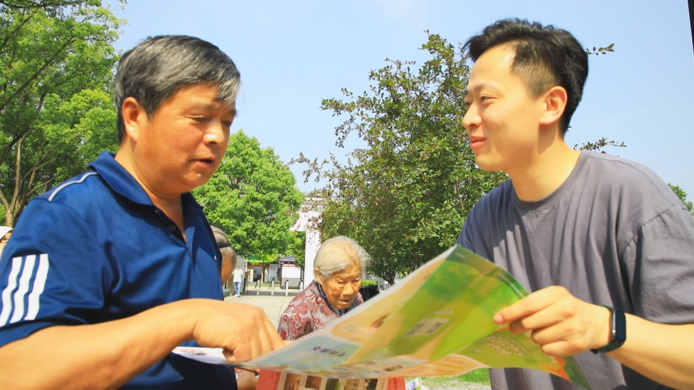 圖為工作人員正在為過往游客介紹桐城市旅游導(dǎo)覽圖.jpg