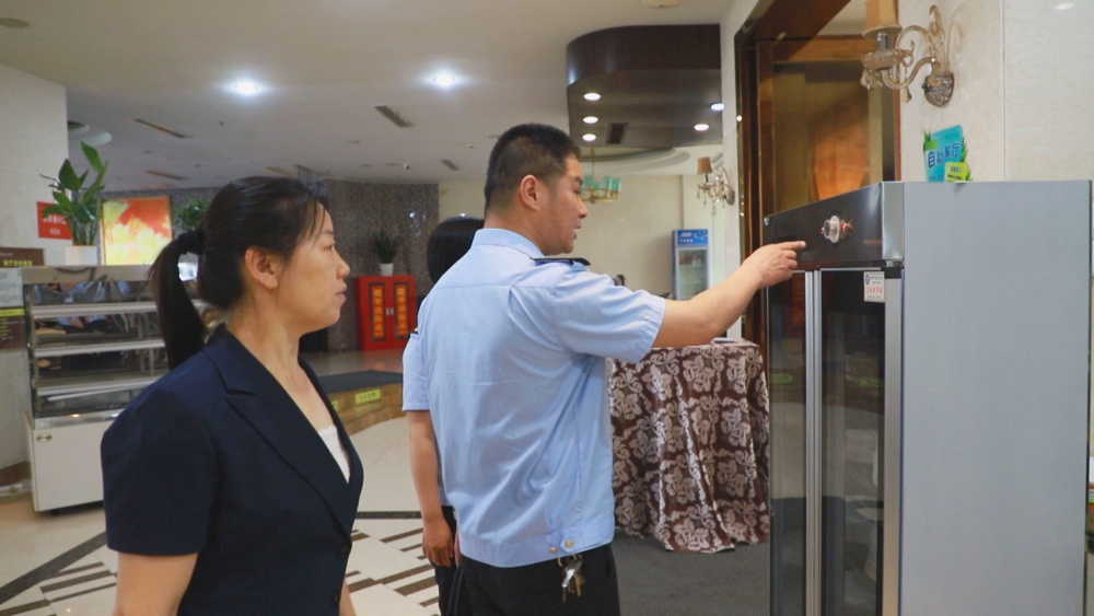 圖為市場(chǎng)監(jiān)管局工作人員正在考點(diǎn)餐飲場(chǎng)所檢查食品安全.jpg