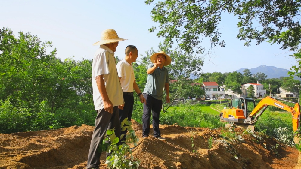 圖為當(dāng)?shù)劓?zhèn)村干部、村民一起現(xiàn)場檢查道路硬化工程施工質(zhì)量.jpg