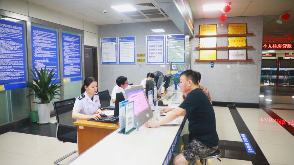 圖為呂紅生正在稅務窗口辦理業(yè)務.jpg
